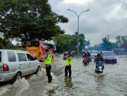 Anggota Polsek Kalidoni Atur Lalu lintas di Tengah Banjir didepan PDAM Kalidoni